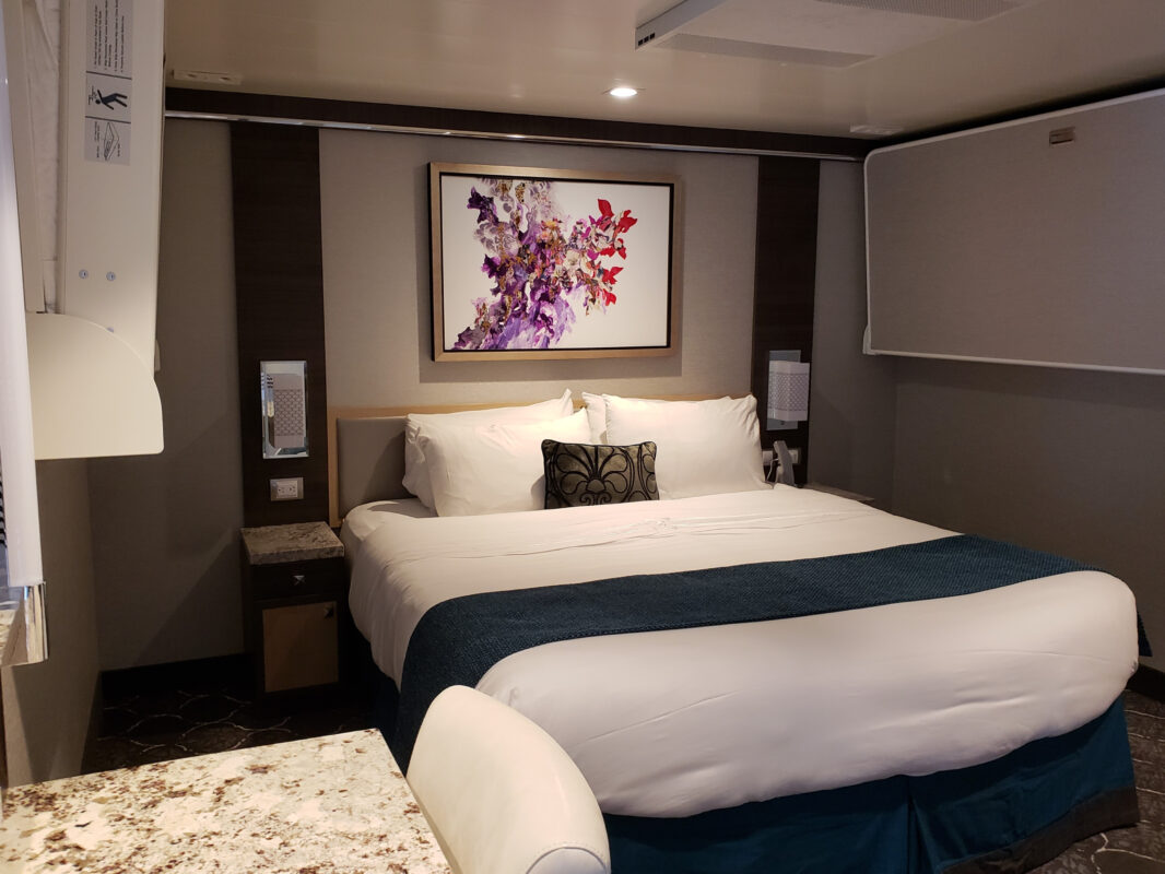 A well-designed inside cabin with a king-size bed and modern decor, showing why some travelers consider it the best cabin for an Alaska cruise.