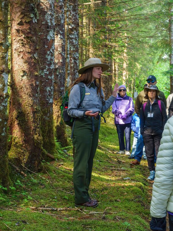 A National Park Service ranger leading a group of cruise passengers on a guided nature hike in Glacier Bay National Park, Alaska.