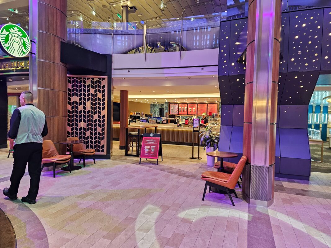Starbucks outlet inside a cruise ship, showing the café counter, baristas, and seating area near the Royal Esplanade.