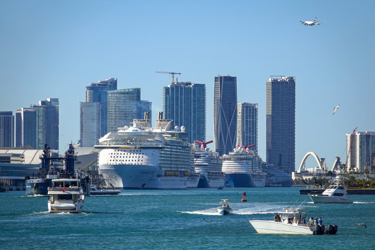 View of PortMiami featuring multiple cruise ships, city skyline, and recreational boats in the foreground.