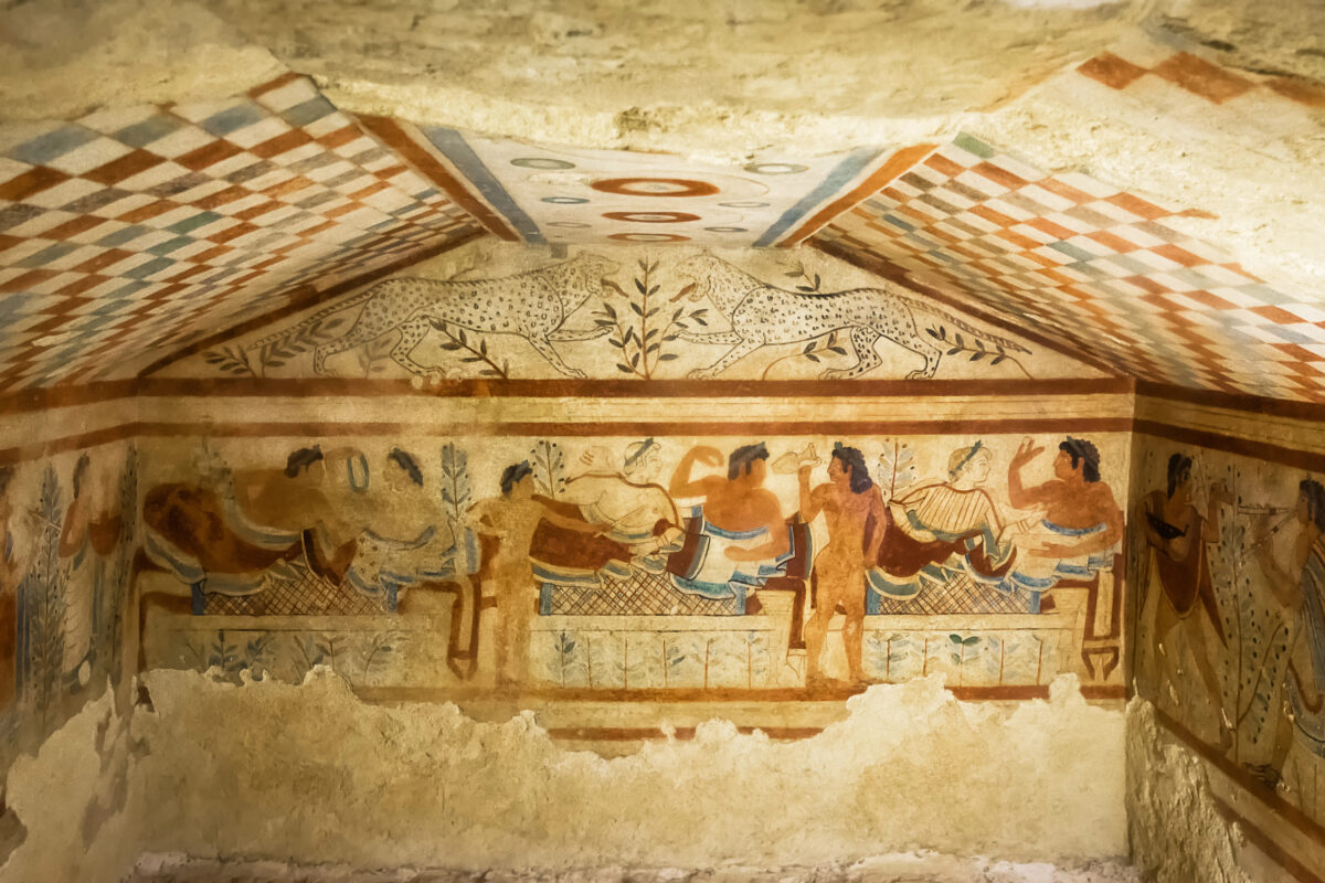 Interior wall fresco from the Etruscan Tomb of the Leopards in Tarquinia, showing reclining figures at a banquet with musicians and leopards painted above.