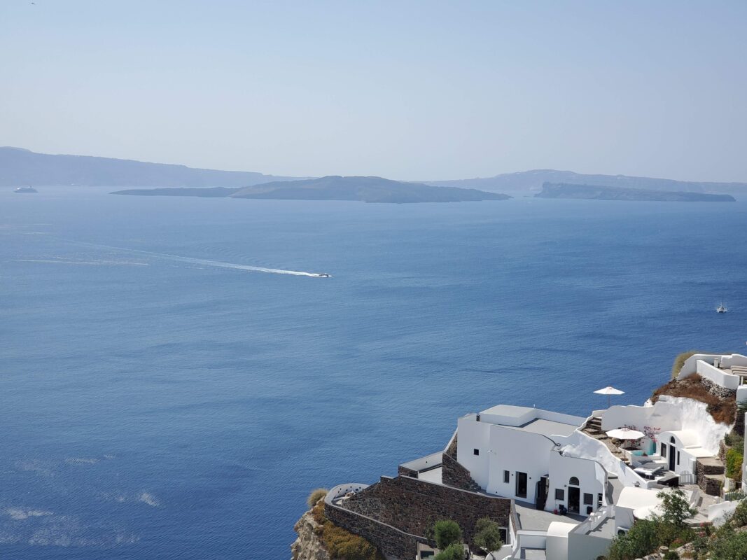 Oia cliffside architecture with sweeping caldera views across the blue waters of Santorini.