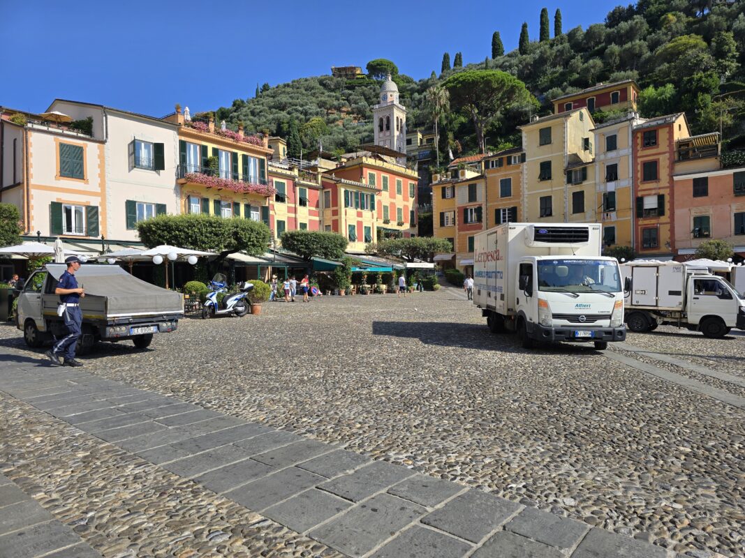 Morning deliveries at the Portofino cruise port, blending local routines with high-end boutiques and megayachts nearby.