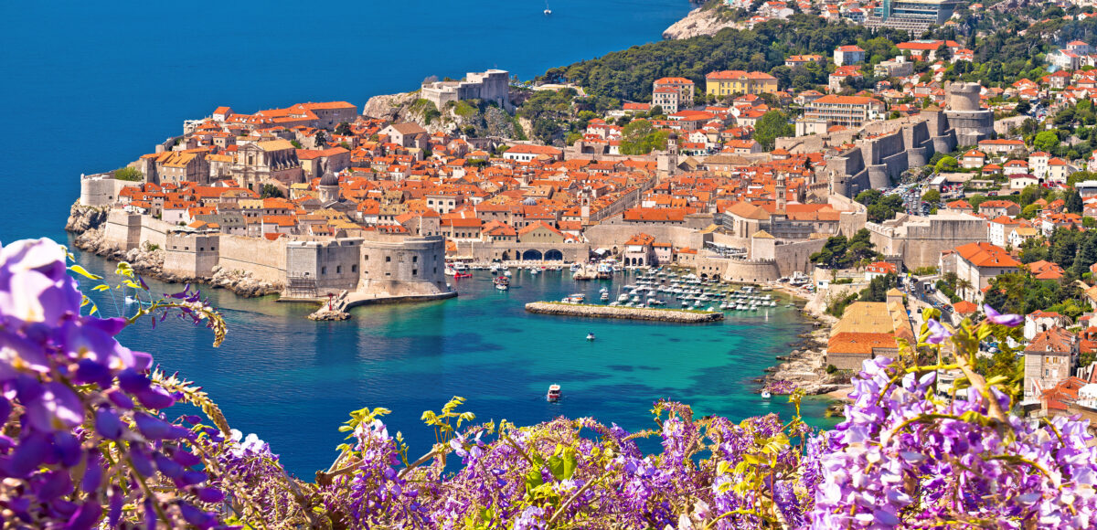 Dubrovnik’s fortified Old Town surrounded by medieval walls and turquoise sea, viewed from above.