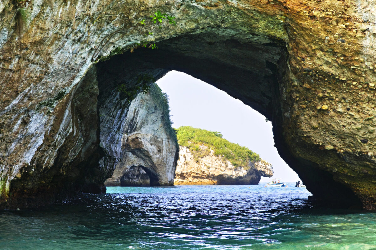 Small tour boats near the Marietas Islands where visitors explore caves and snorkel in clear Pacific water.