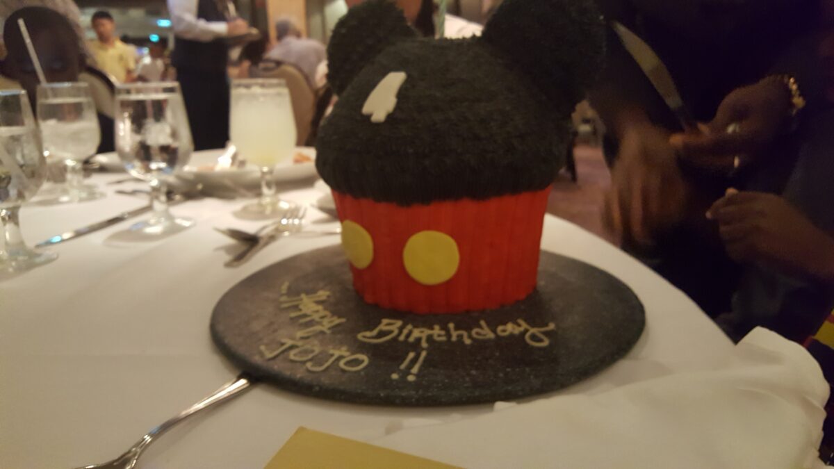 Decorative birthday cake on a cruise ship restaurant table, prepared in advance for a special occasion.