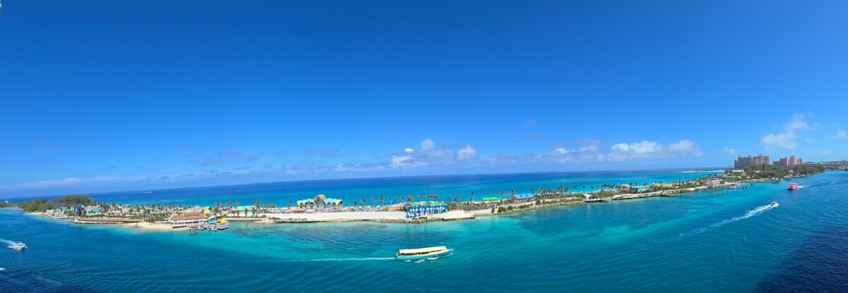 Wide panoramic photo of Royal Beach Club Paradise Island showing beaches, buildings, and surrounding blue water as seen from a ship.
