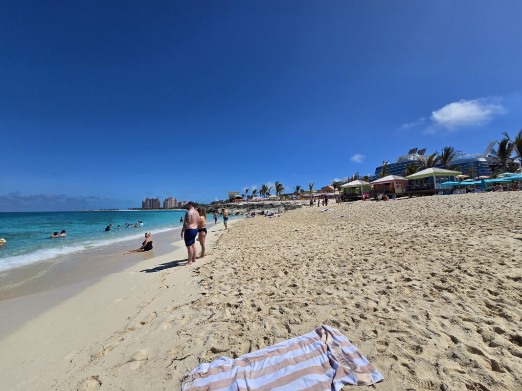 View down the beach at Royal Beach Club Paradise Island with Atlantis visible in the distance across Paradise Island.