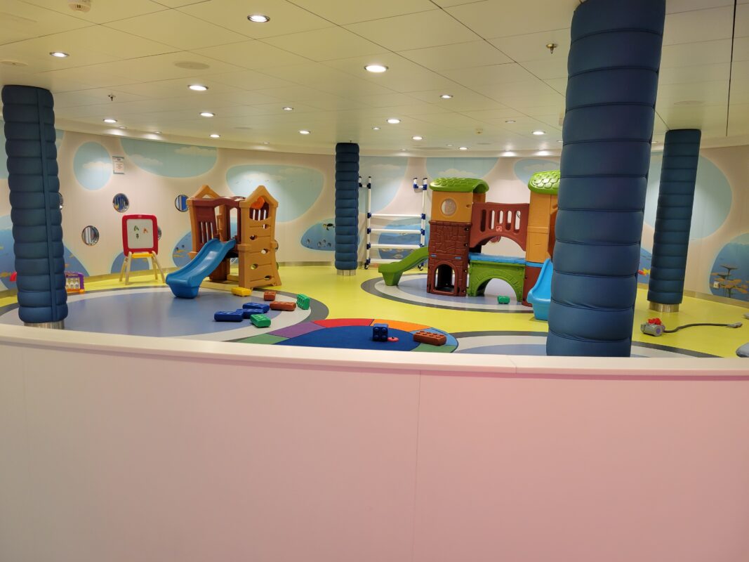 Cruise ship toddler playroom with colorful climbing structures and toys, illustrating an open play area rather than drop off care.