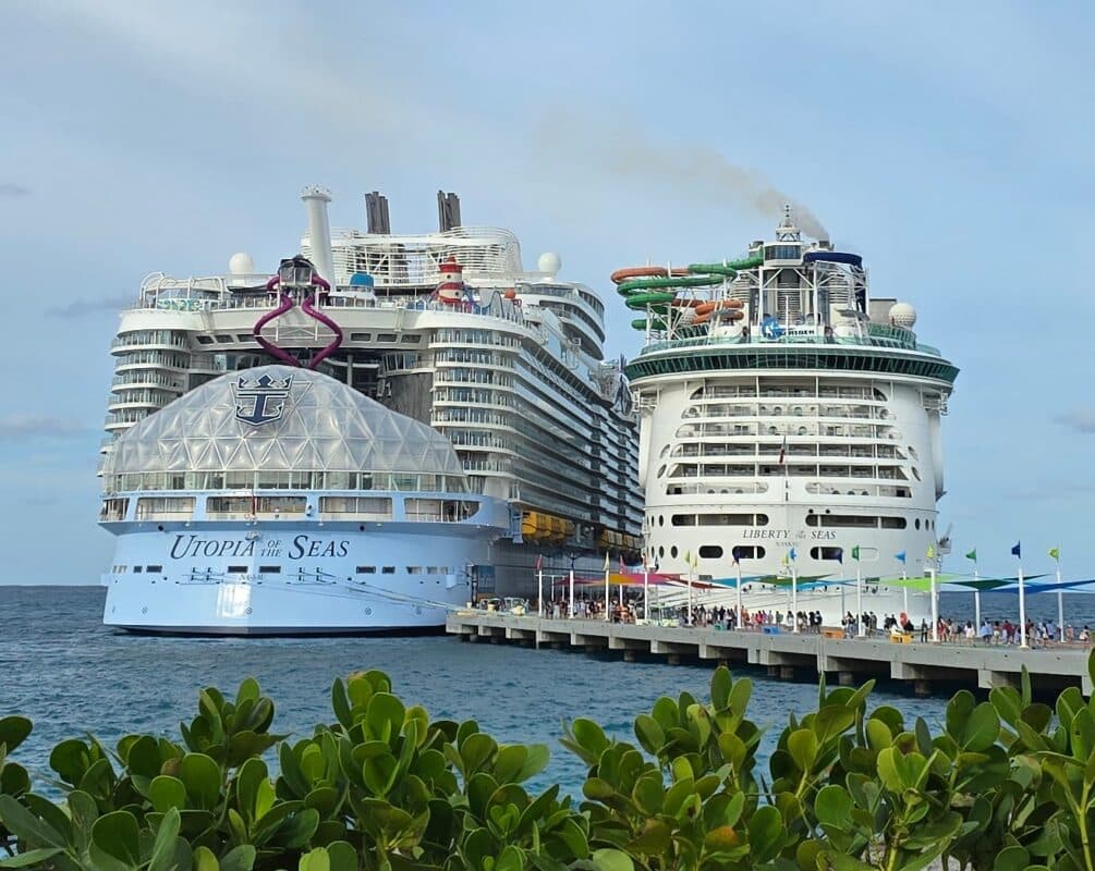 Utopia of the Seas and Liberty of the Seas docked side by side, showing the size difference between newer and older Royal Caribbean ships.