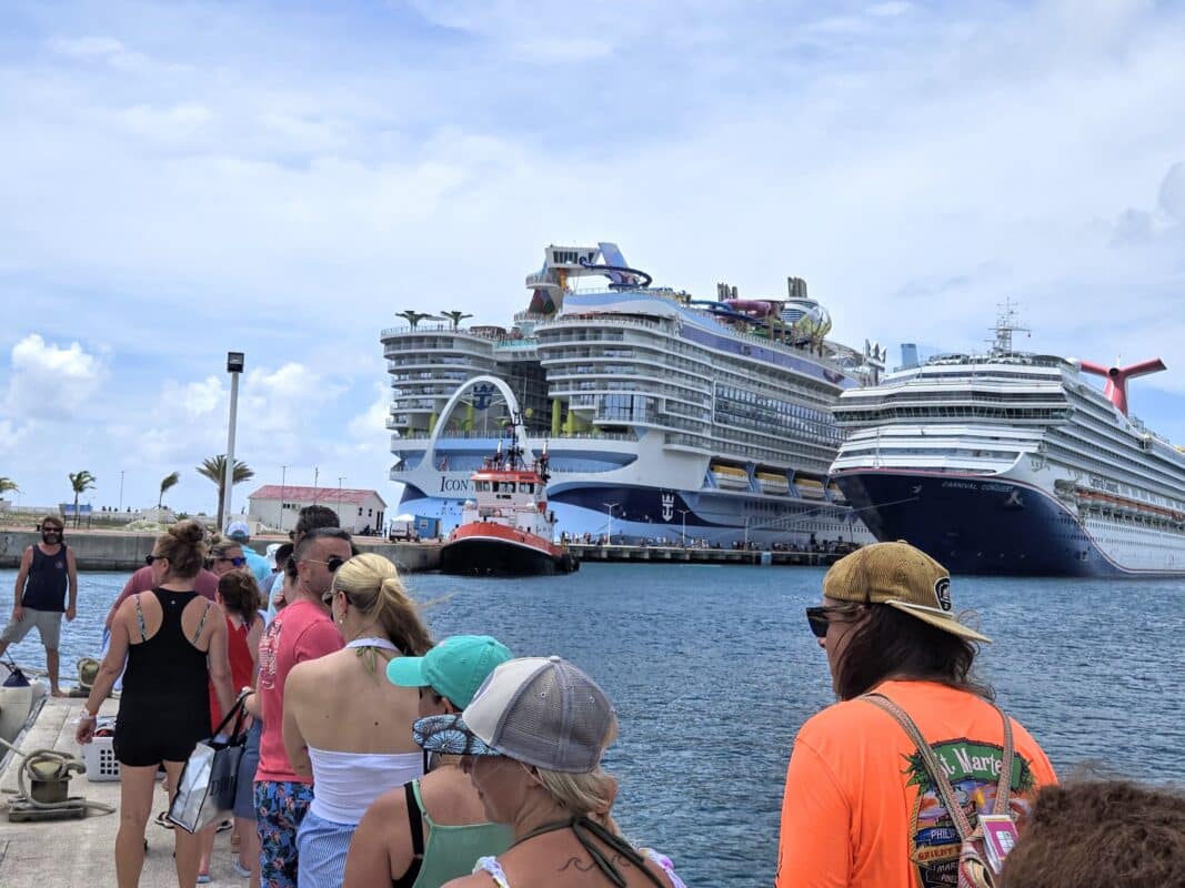 Side-by-side view of 2002-built Carnival Conquest and 2024-built Icon of the Seas in port.